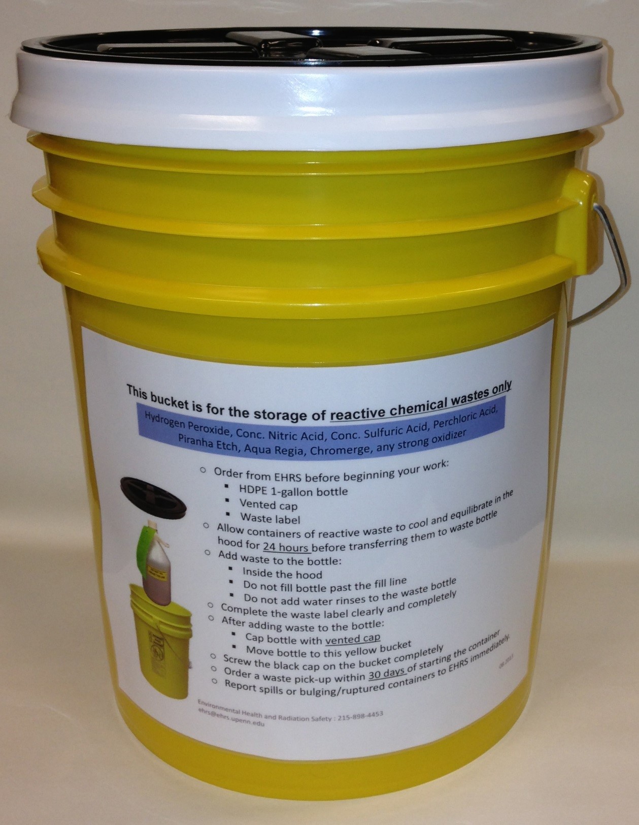 Yellow 5-gallon plastic bucket with black screw top lid and instructions sign affixed to side